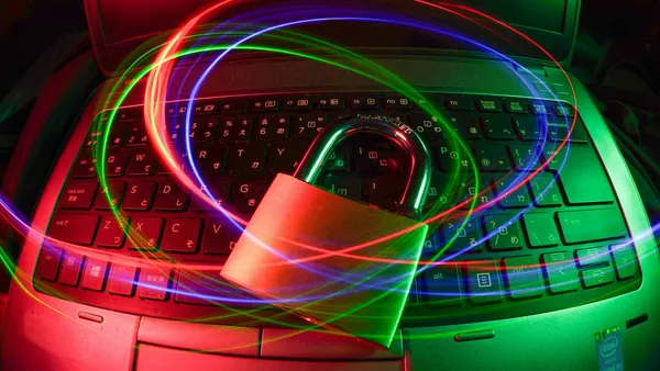 A padlock resting on a laptop keyboard with light trails