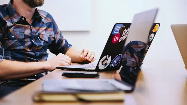 Product team member discussing interface ideas beside a laptop