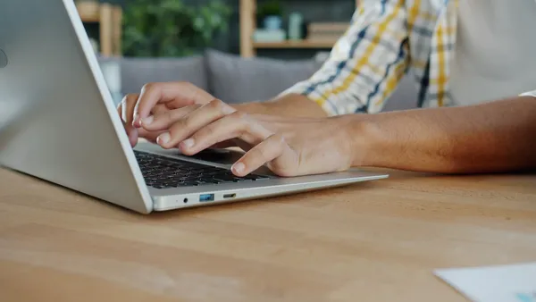 Close-up of hands typing on a laptop computer keyboard