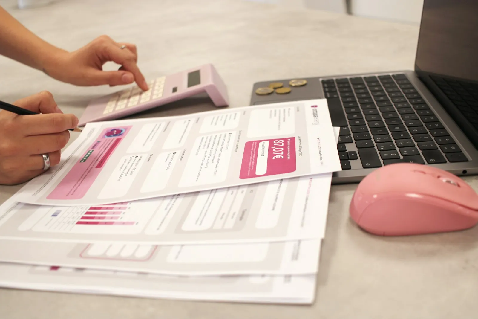 Someone calculating costs with a calculator and printed reports