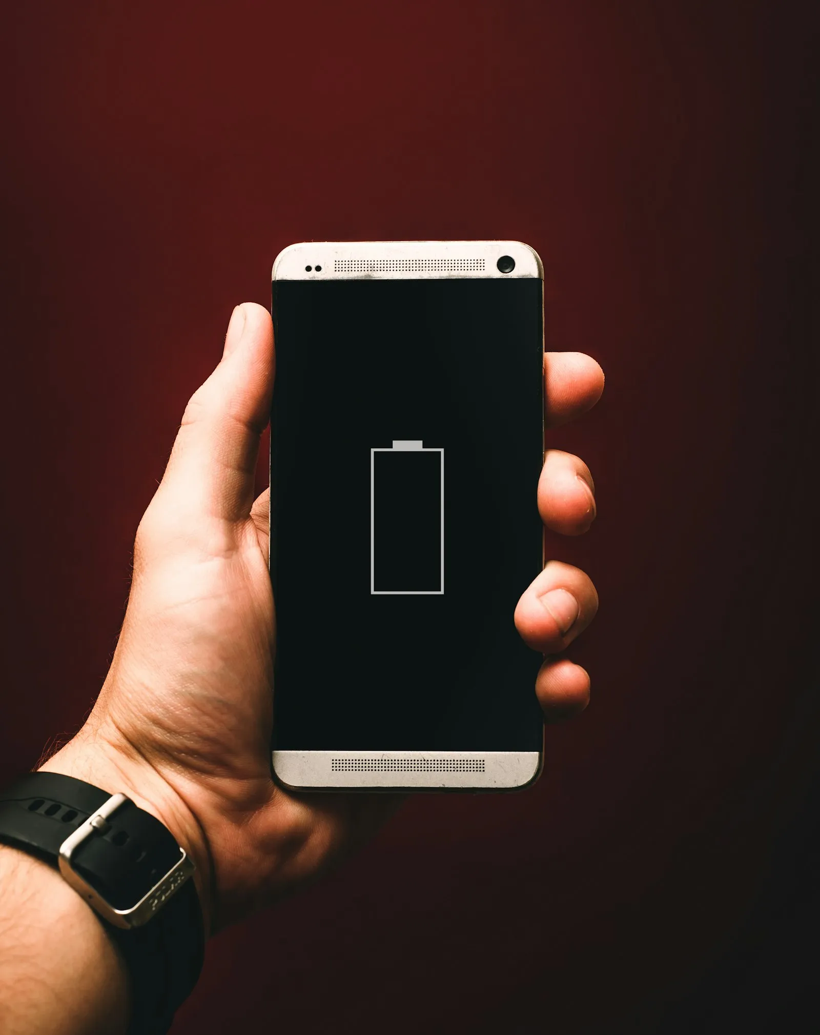 Person holding a smartphone showing a low battery warning